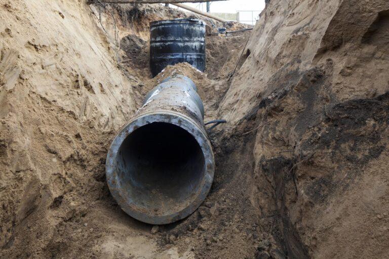 Wide and deep trench with massive exposed pipe.