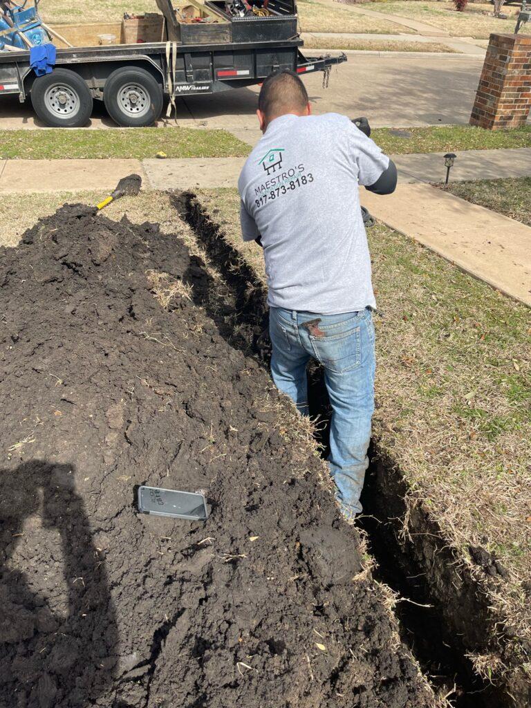 Worker digging out channel for Drainage System